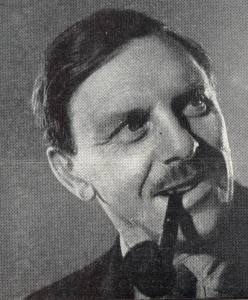 Black and white photo of a middle-aged mustached man smoking a pipe.